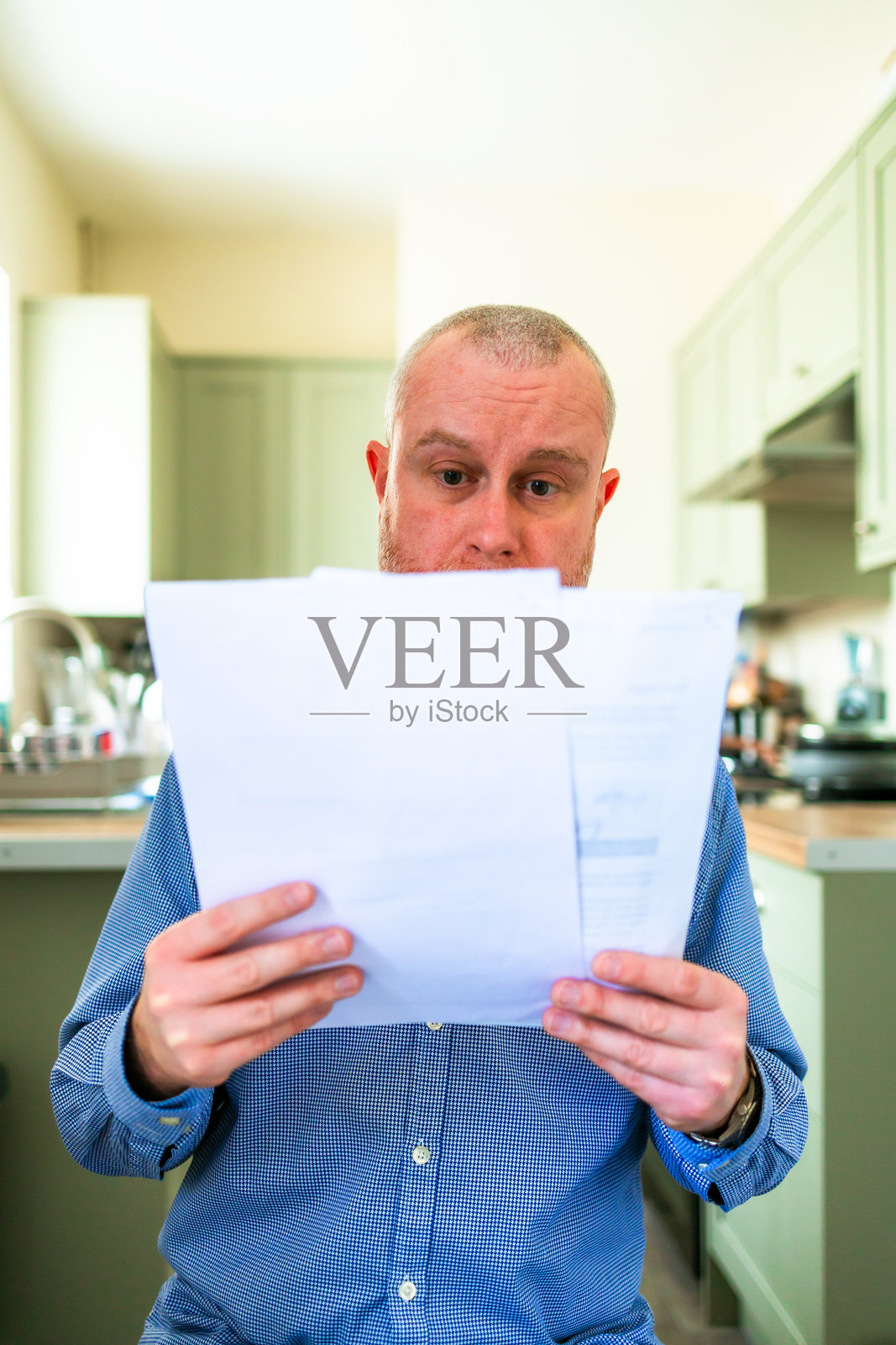 担忧的中年职业男性在家查看账单照片摄影图片