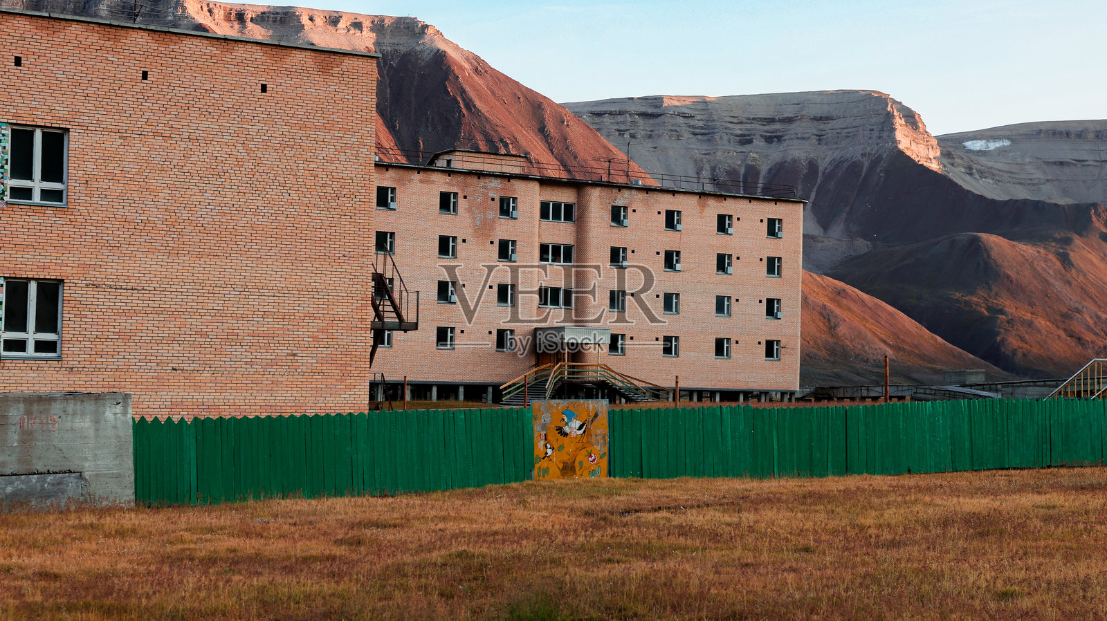 在斯瓦尔巴群岛的皮拉米登探访废弃建筑，享受黄金时刻的美景照片摄影图片