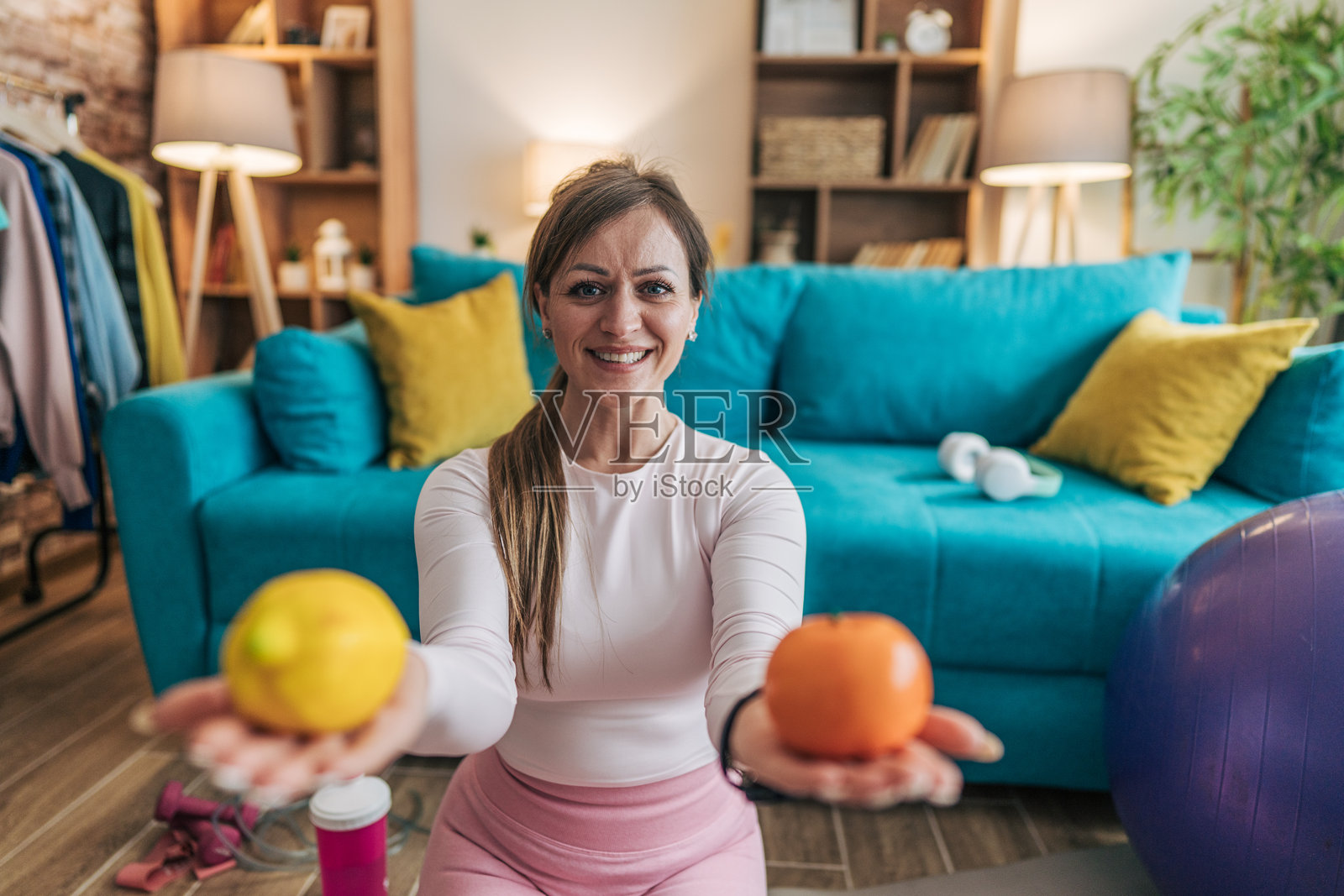 健身女性在家庭锻炼后展示橙子和柠檬照片摄影图片