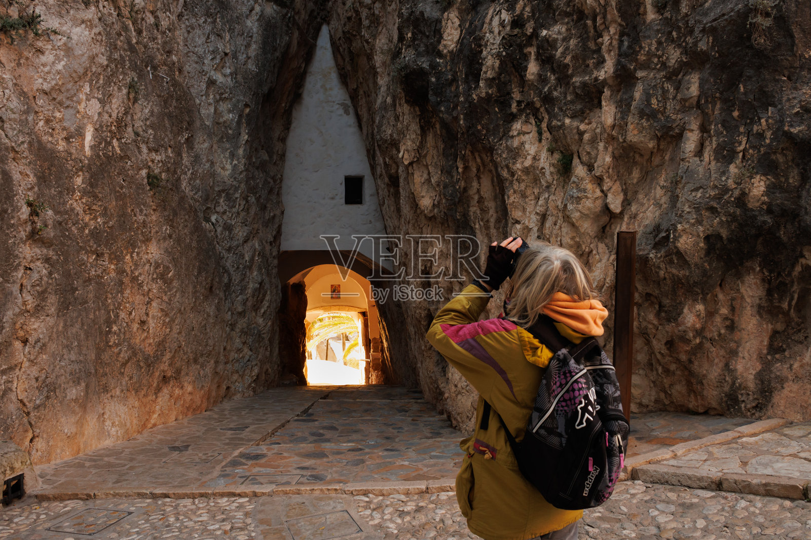 游客在拍摄通往历史名城瓜达莱斯特的岩石通道照片摄影图片