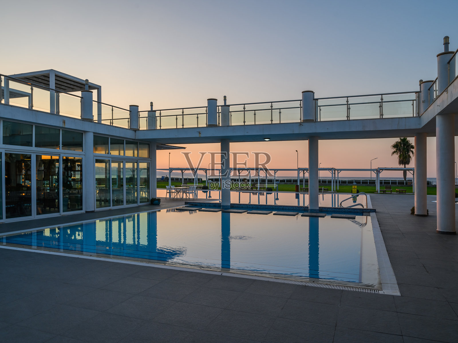 优雅泳池区的日落，宁静环境中映射出鲜艳的色彩照片摄影图片