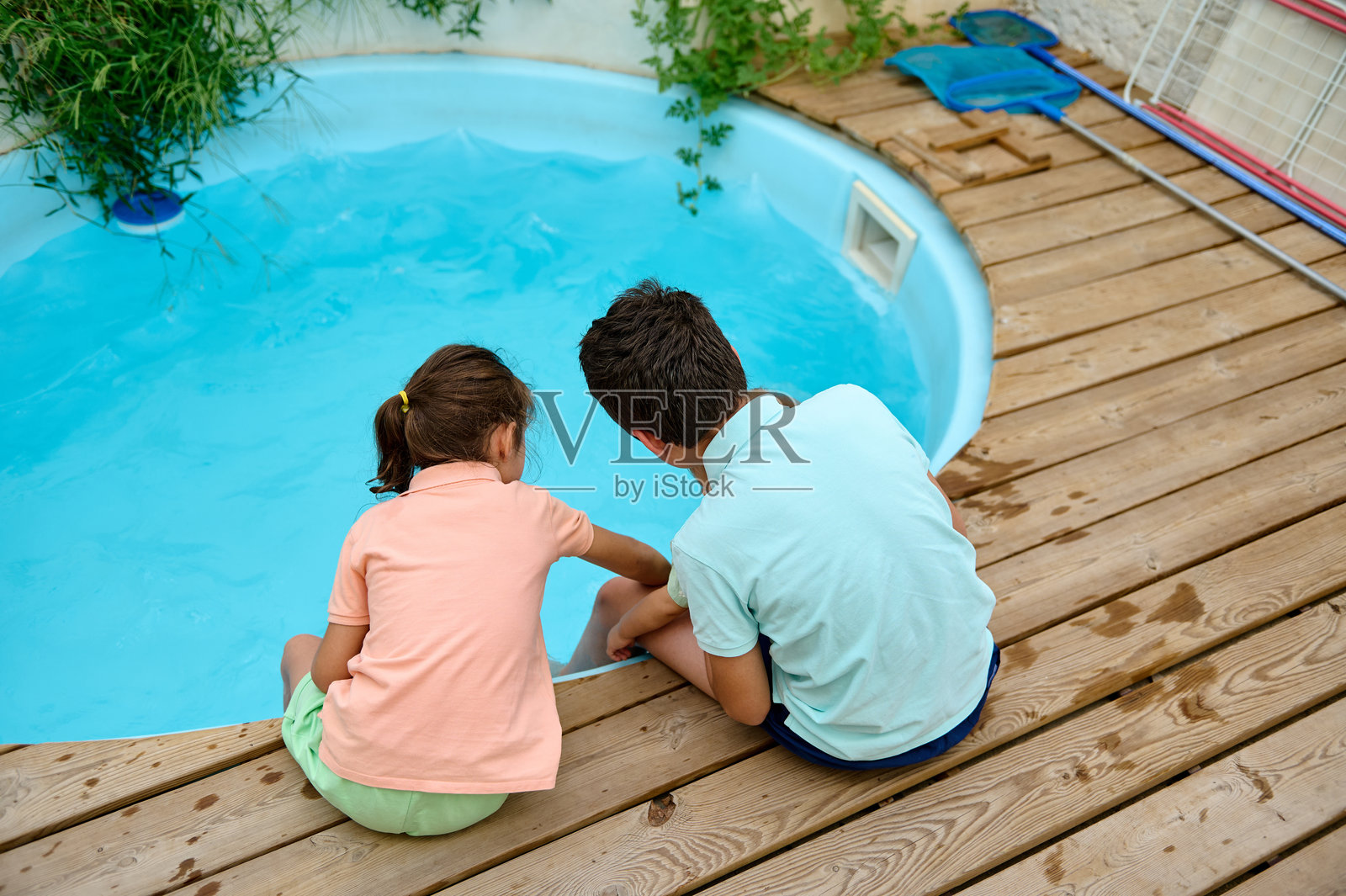 孩子们在后院游泳池旁享受美好时光照片摄影图片