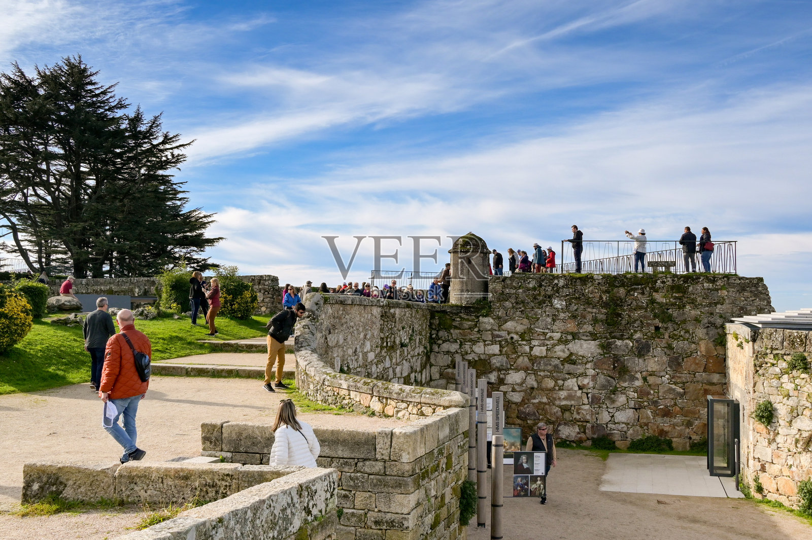 游客在埃尔卡斯特罗城堡的城墙上俯瞰维戈市。照片摄影图片