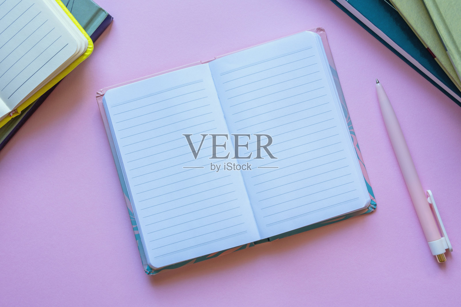 粉色背景上的空白笔记本、书籍和钢笔。留白空间。照片摄影图片