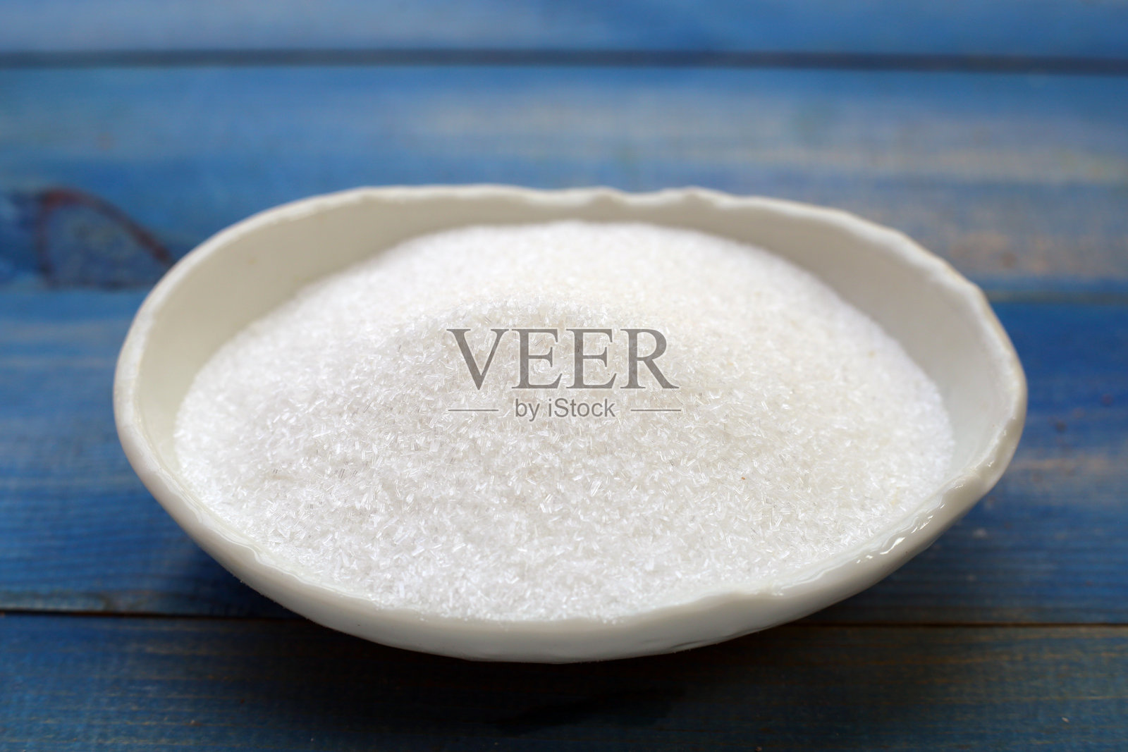 木质背景上的碗中盛有单钠谷氨酸。照片摄影图片