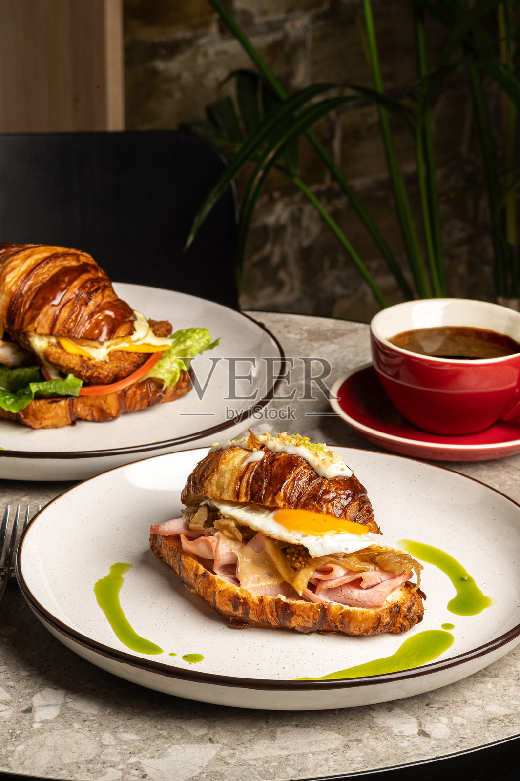 舒适咖啡馆环境中的美味可颂三明治与咖啡照片摄影图片