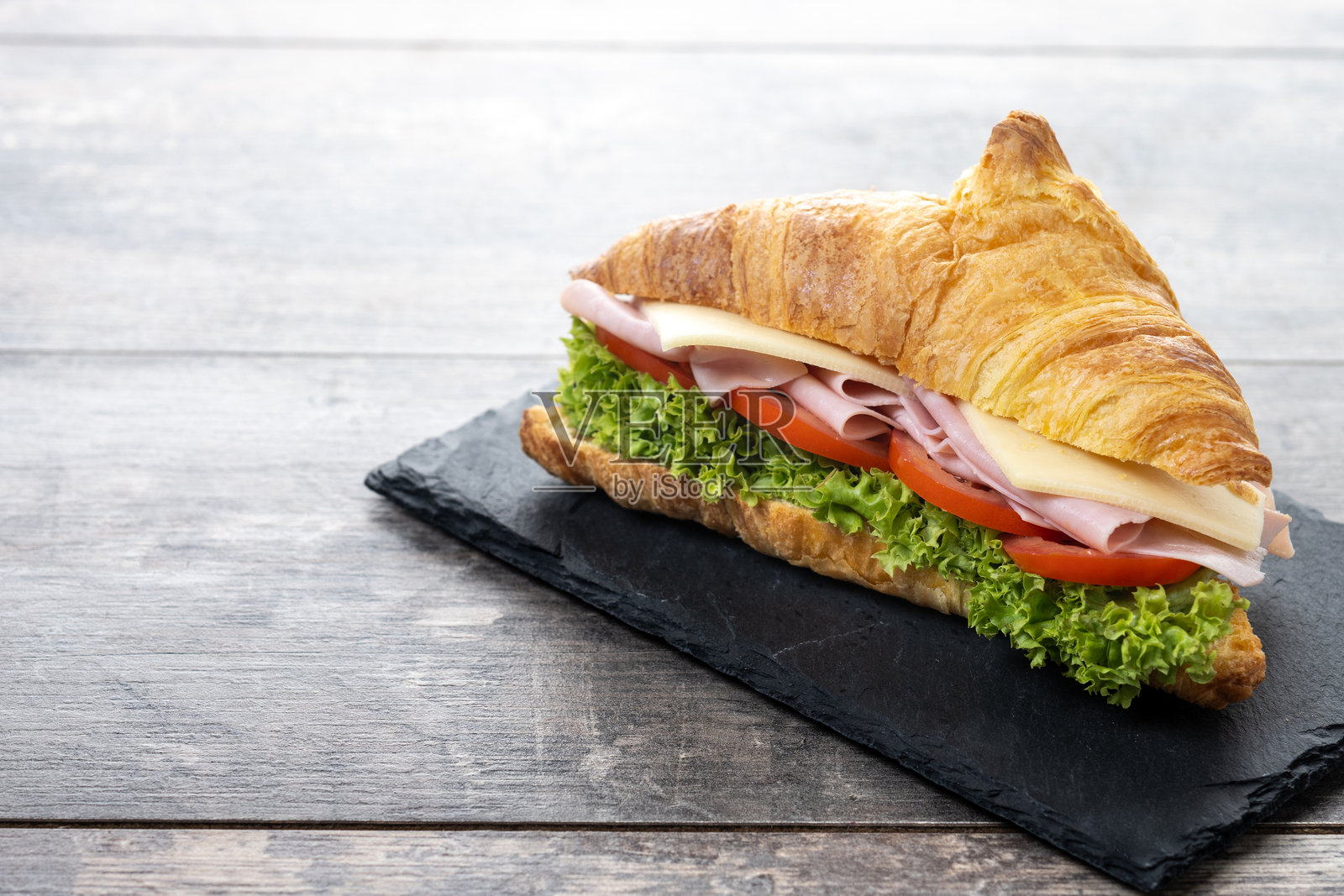 木桌上的火腿、奶酪和蔬菜可颂面包照片摄影图片