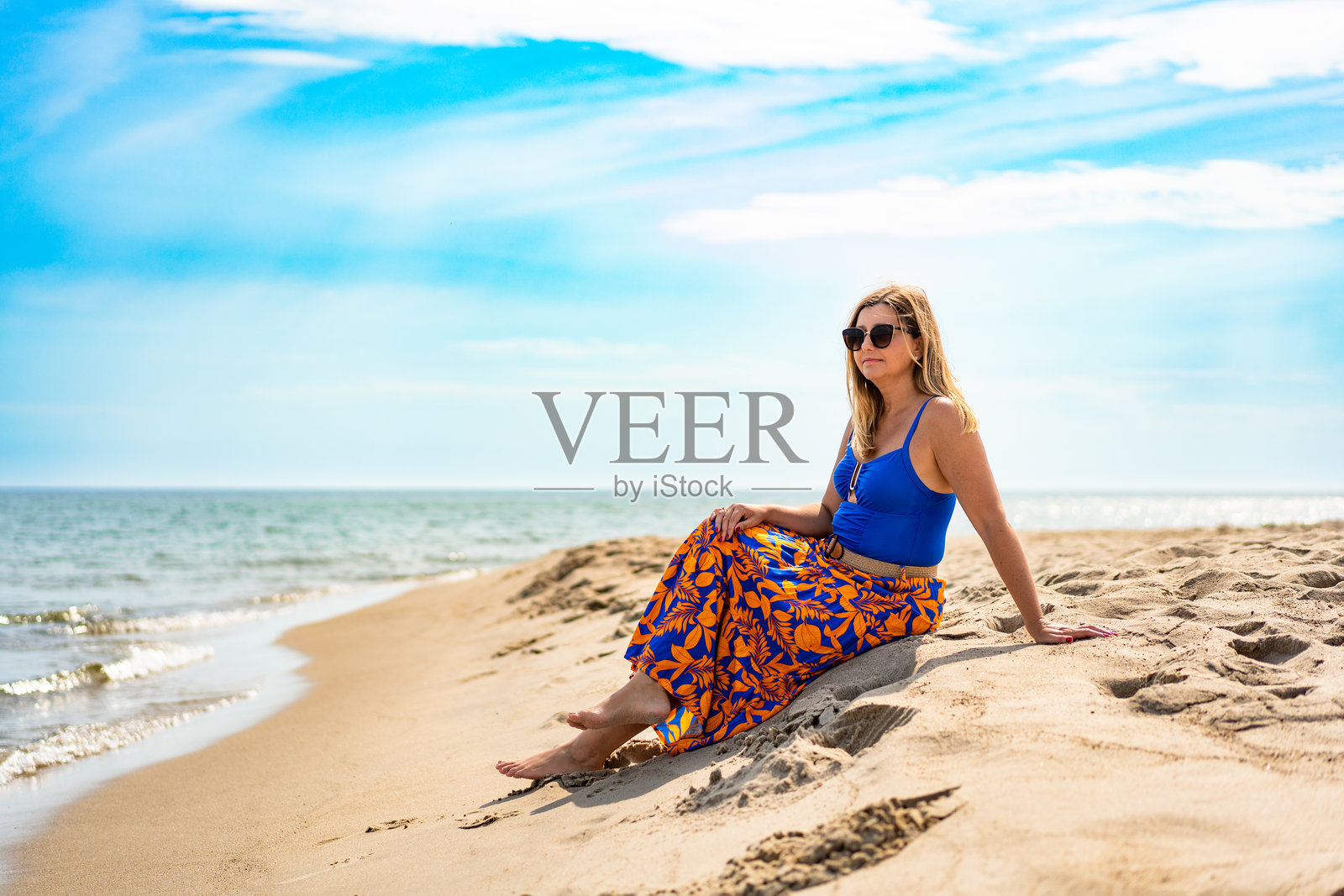 成熟的女性在海滩享受假期照片摄影图片