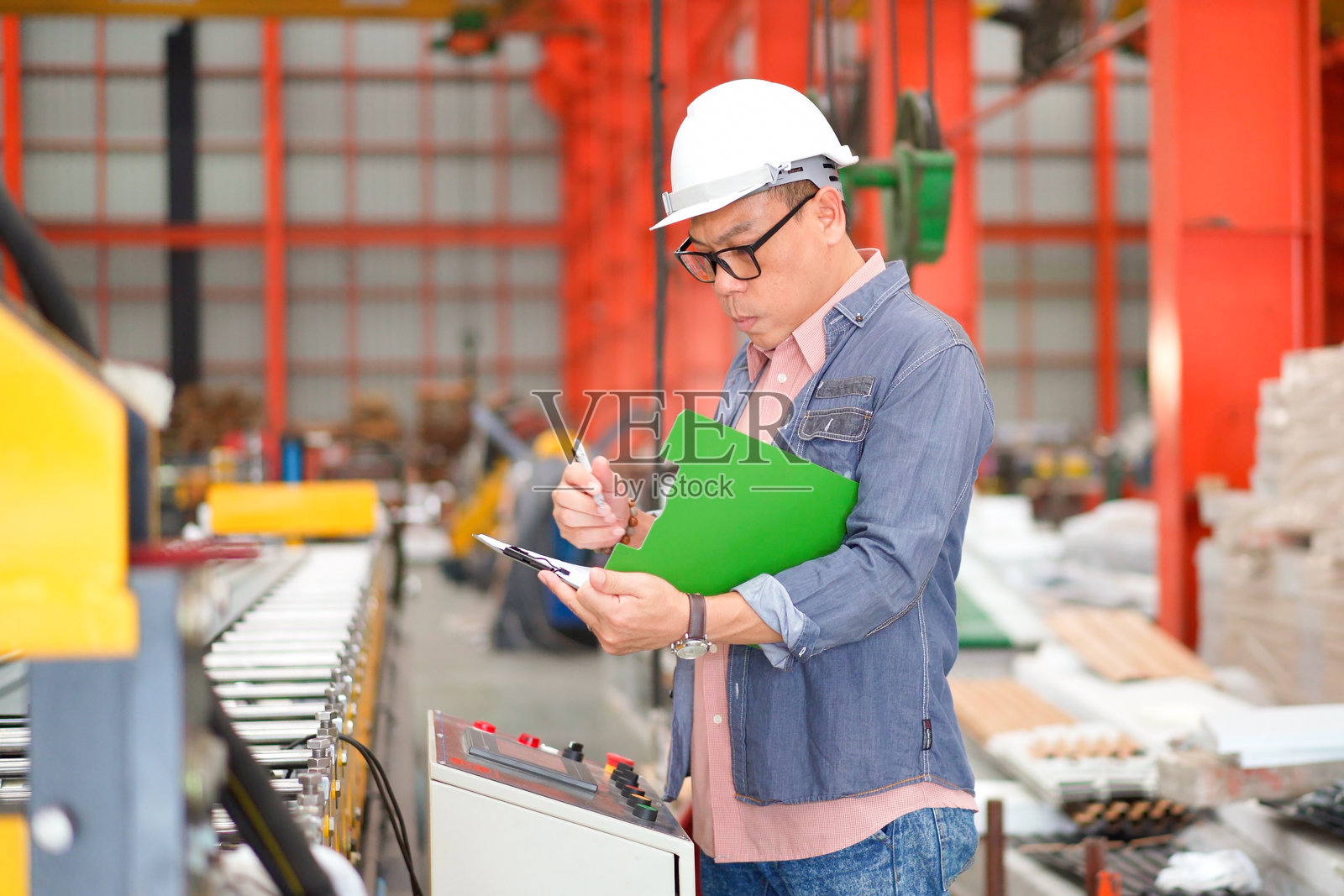 高级工业工程师在工厂内工作或检查。照片摄影图片