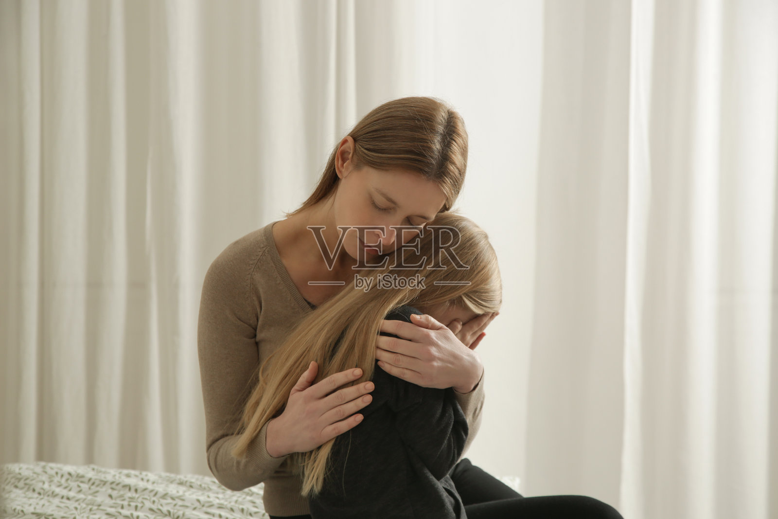 关心的妈妈安慰她伤心的小女孩照片摄影图片