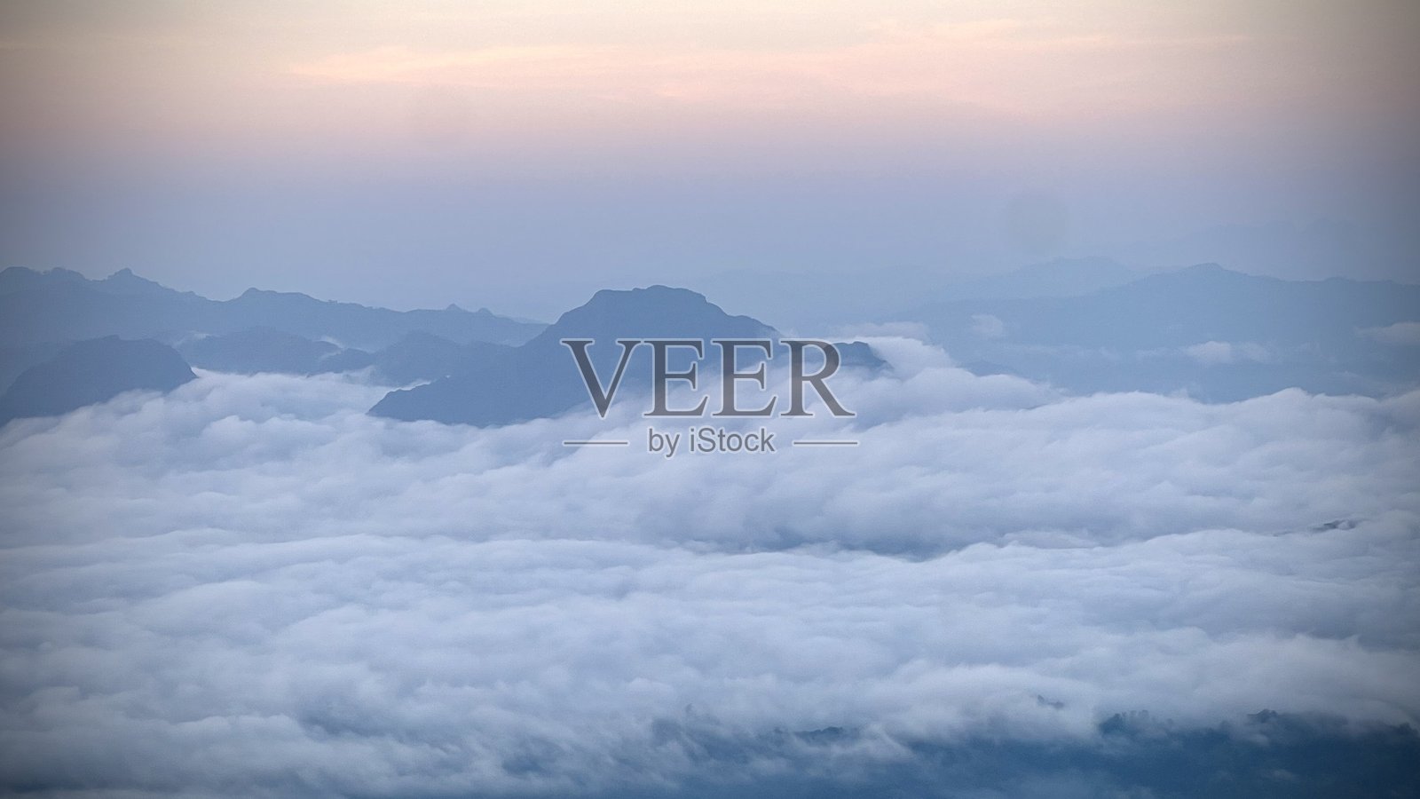 日出时分山顶的雾气，壮丽的晨雾笼罩着山峦。照片摄影图片