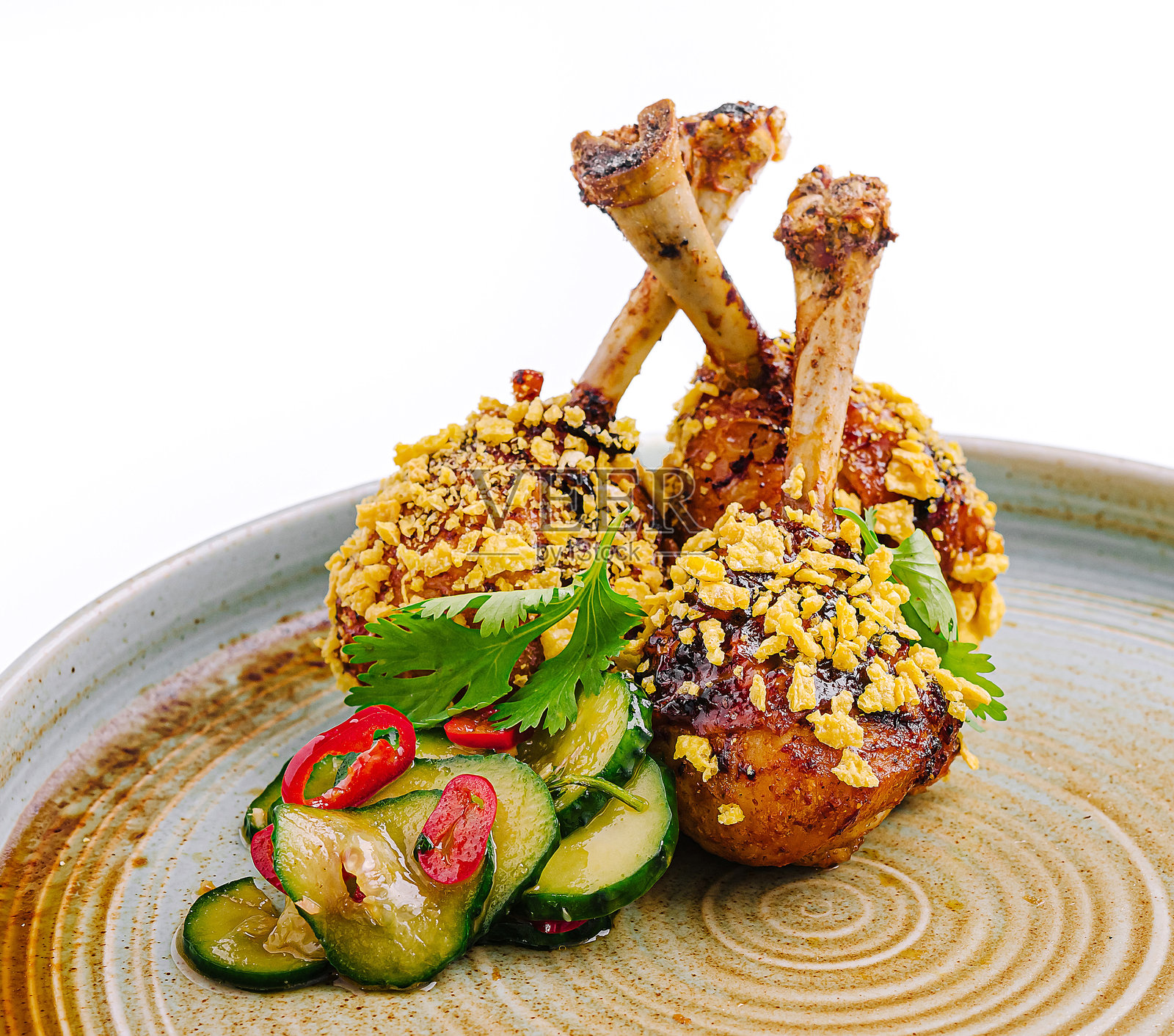 美味的鸡腿配上酥脆的外皮和清爽的黄瓜沙拉，摆放在一个乡村风格的盘子上照片摄影图片