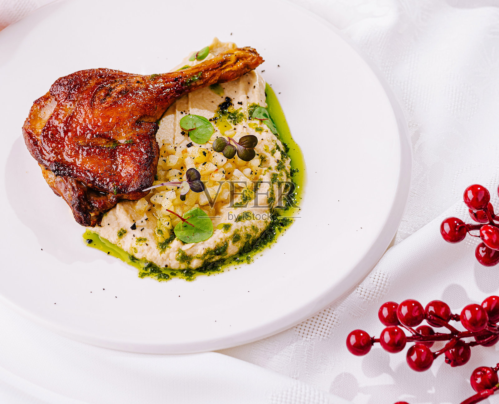 美味的鸭腿配上奶油土豆泥和节日装饰，适合特殊场合。照片摄影图片