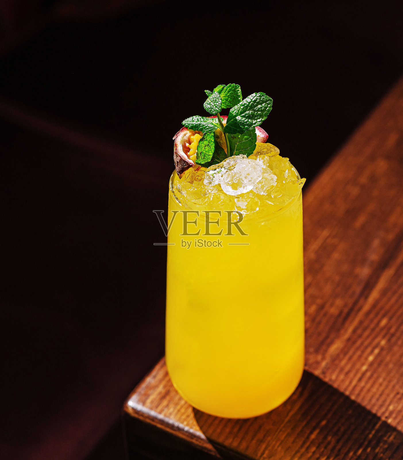 清爽的热带鸡尾酒，配以薄荷装饰，摆放在温馨环境中的木桌上照片摄影图片