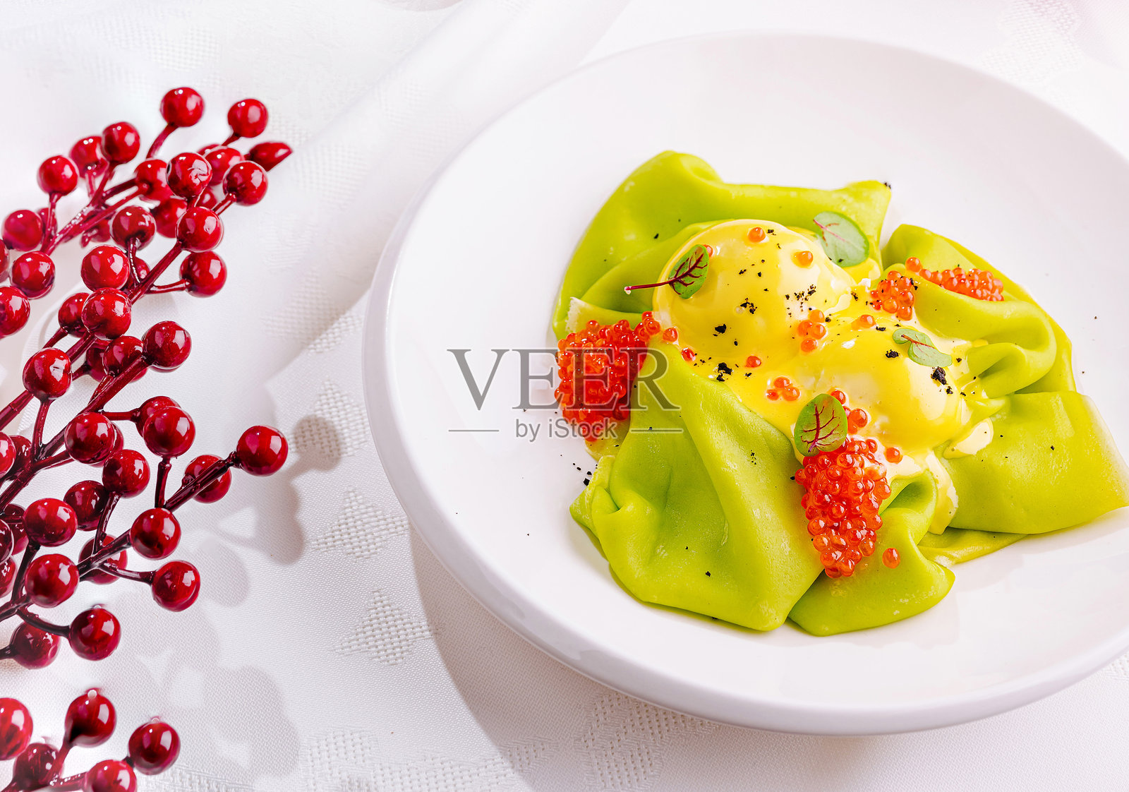 节日美食优雅地摆放在白色桌布上，配有红色装饰和蜡烛照片摄影图片