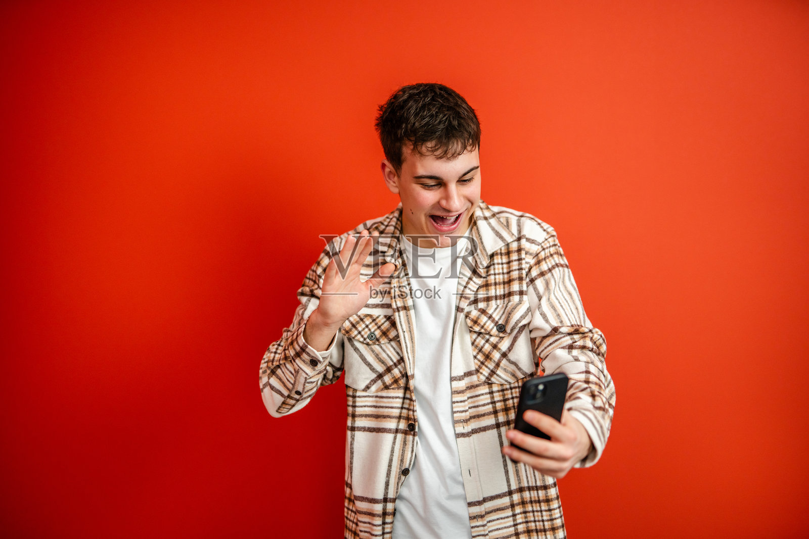 年轻男子在摄影棚中通过手机进行视频通话照片摄影图片