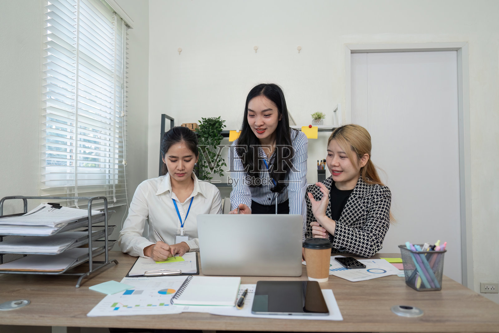 多元化的商业团队在办公室围绕笔记本电脑合作并分享想法。照片摄影图片