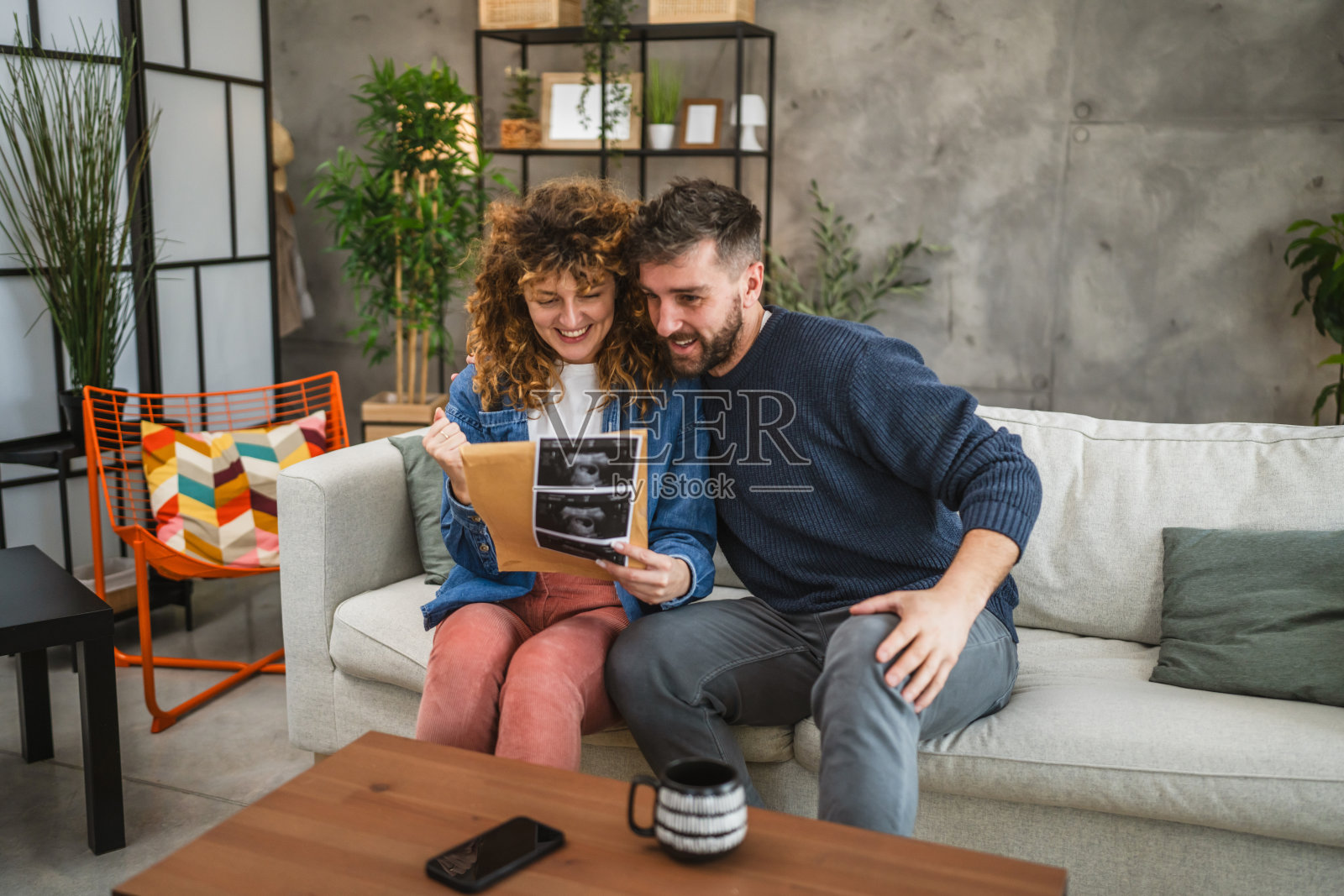 一对情侣打开信封，里面是他们宝宝的超声波孕期照片照片摄影图片