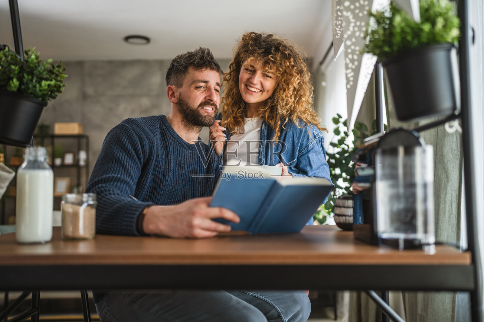 男朋友和女朋友在家里早餐时一起阅读书籍照片摄影图片