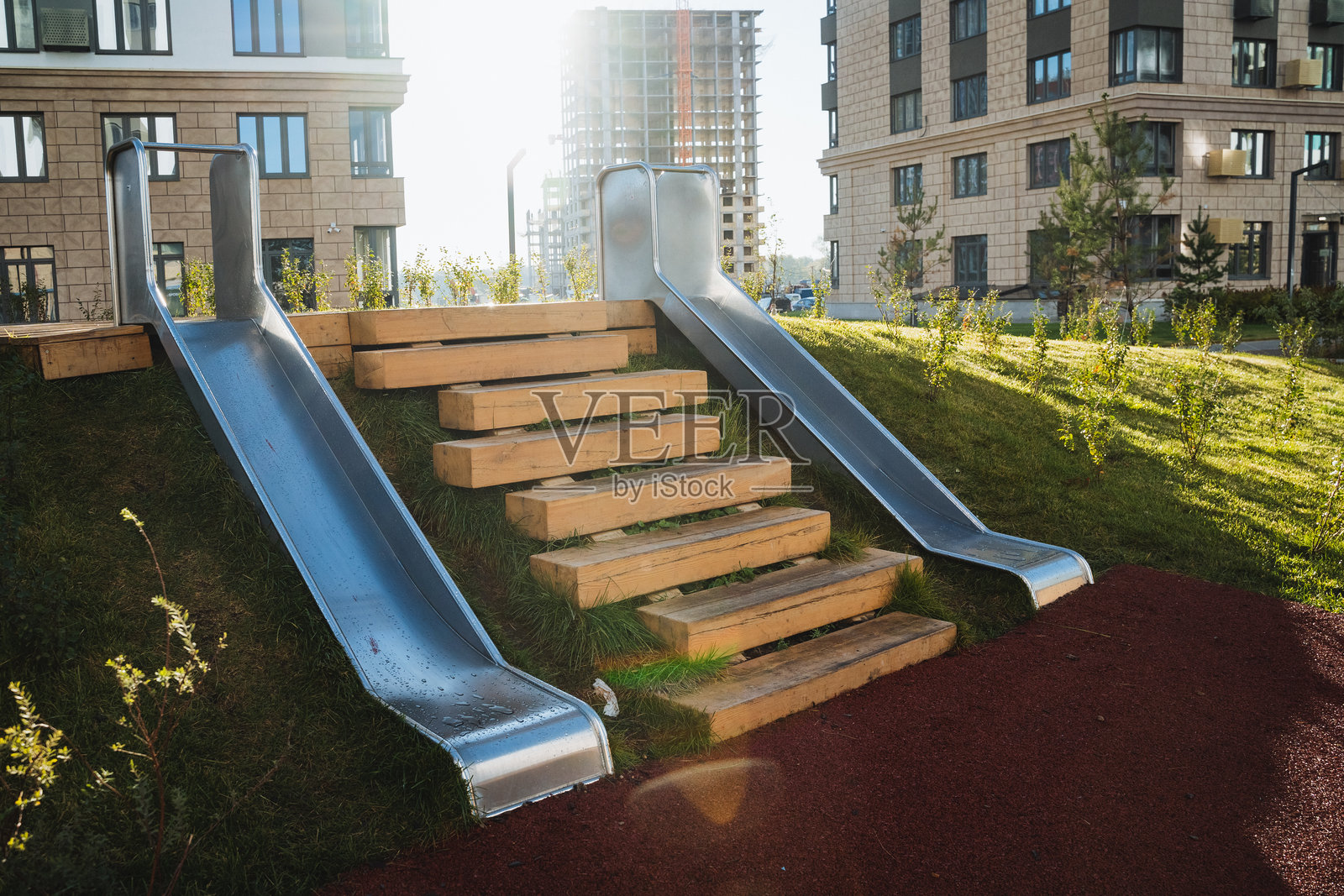 在公共公园里，有一个金属滑梯，旁边是通往滑梯的木制台阶，为孩子们提供乐趣，也是家庭享受休闲时光的好地方。照片摄影图片