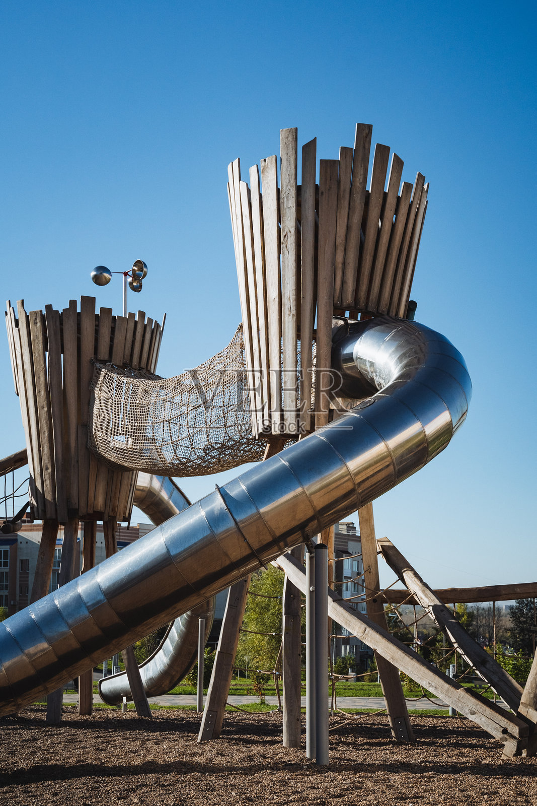 一个专为儿童设计的有趣而吸引人的游乐场，设有令人兴奋的彩色滑梯和坚固的木塔，鼓励富有想象力的游戏和冒险探索。照片摄影图片