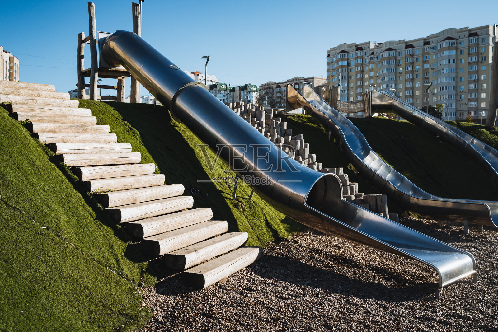 游乐场设有一条闪亮的不锈钢滑梯，配有一套坚固的楼梯通往顶部，成为孩子们玩耍的一个令人兴奋的景点。照片摄影图片