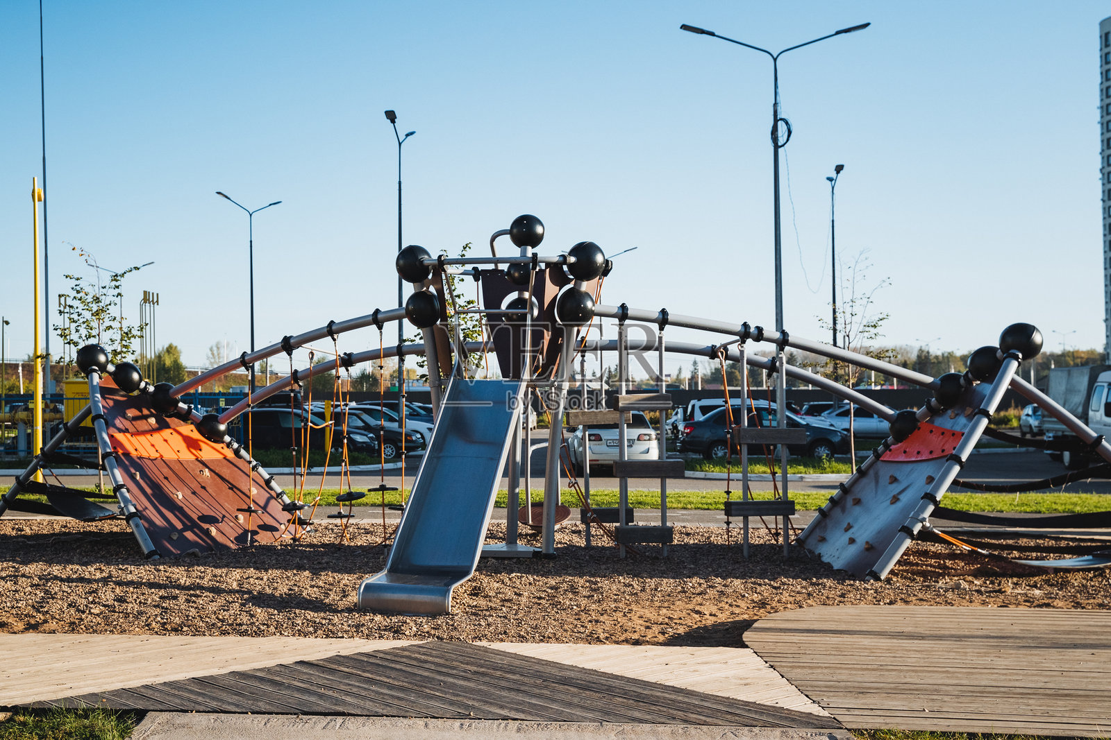 在停车场，有一个充满活力的游乐场，设有高高的滑梯和一个具有挑战性的攀岩墙，为儿童和家庭提供了乐趣和娱乐的机会。照片摄影图片