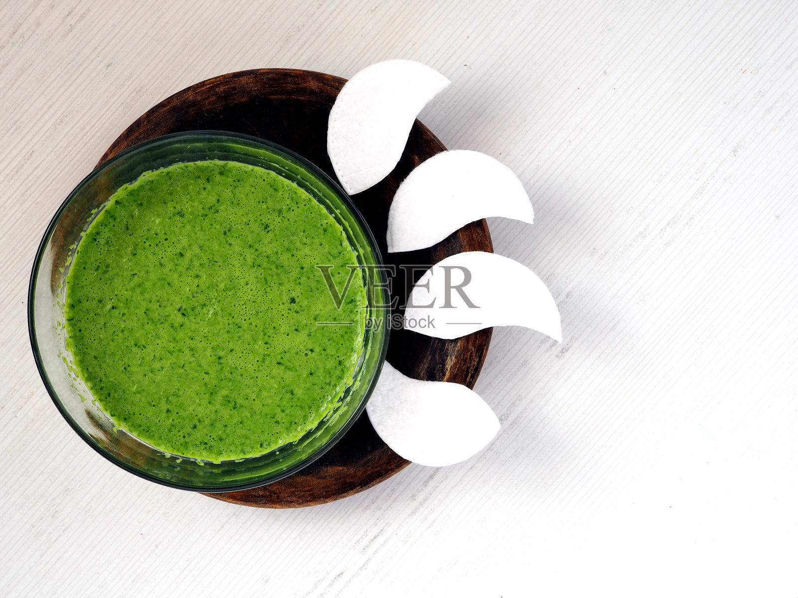 自制黄瓜汁眼贴与新鲜绿色面膜放在木盘上照片摄影图片