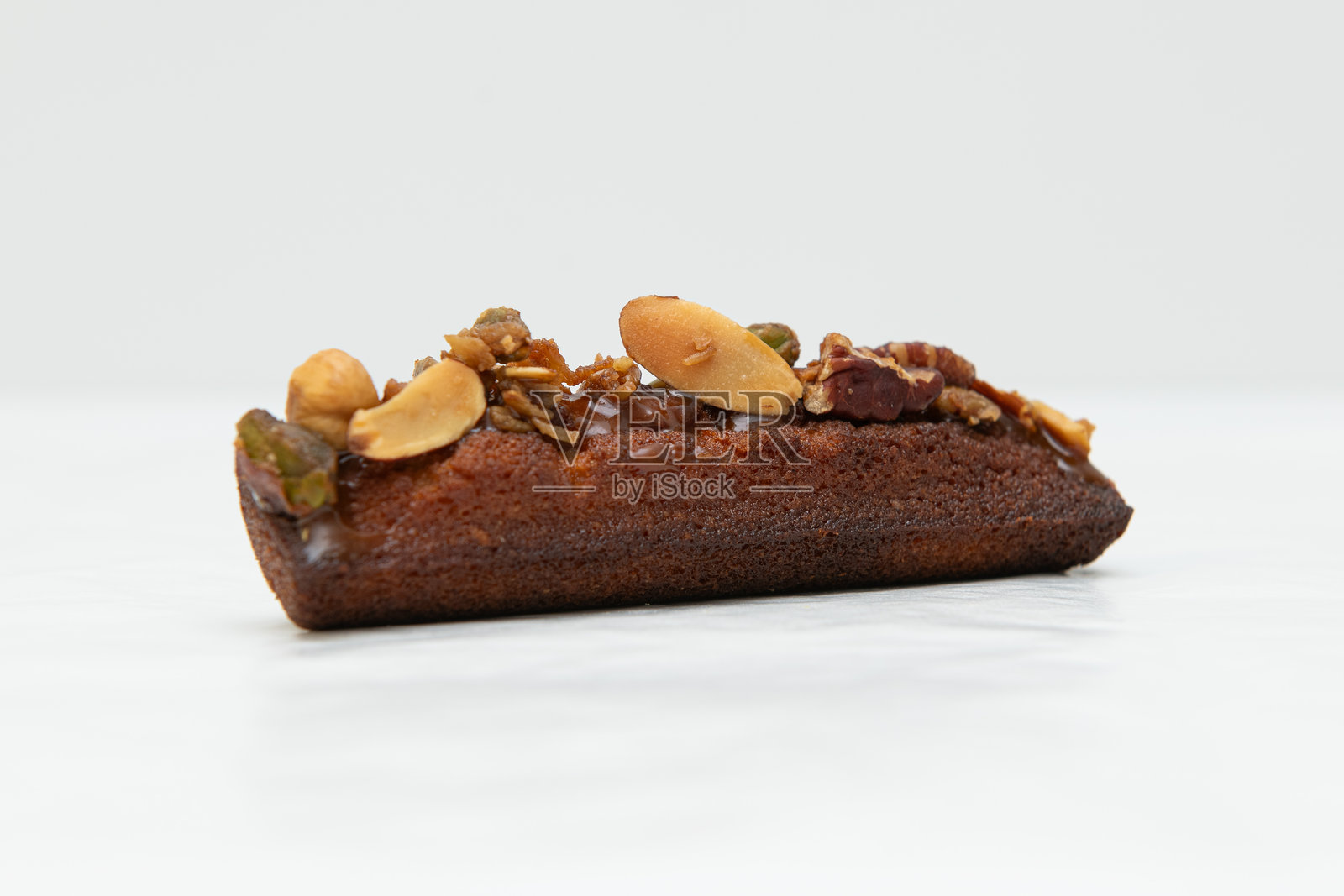 白色背景上的一块巧克力蛋糕，上面撒有坚果。孤立展示。照片摄影图片