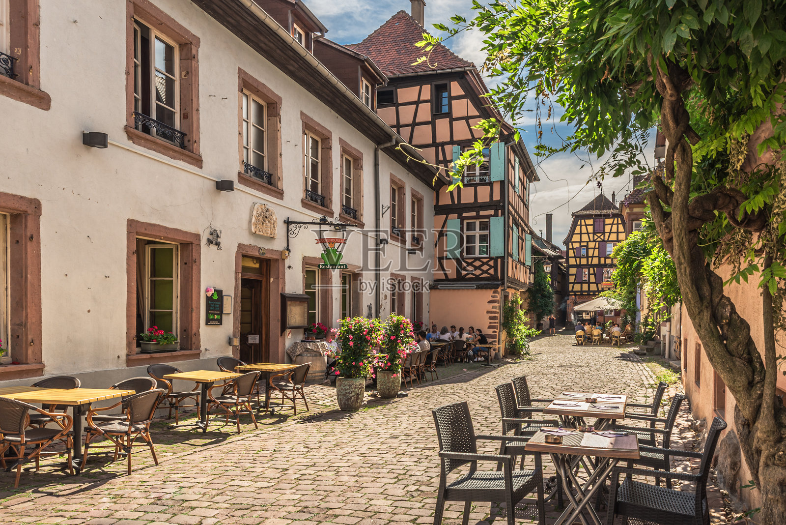 法国阿尔萨斯里夸维尔古镇的街道,两旁是历史悠久的房屋和田园诗般的餐厅。照片摄影图片