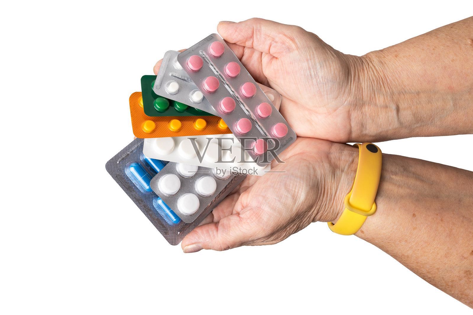 一位年长女性手中拿着各种处方药的泡罩包装，包括抗生素药丸和止痛胶囊，背景为白色。医疗保健，老年护理，医疗治疗概念。照片摄影图片