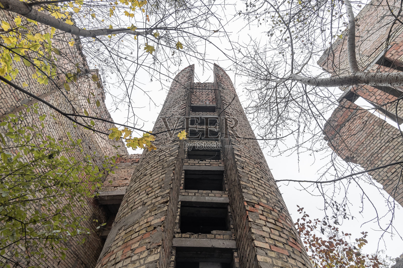 从下面仰视1980年代末文化宫的废弃未完成砖砌建筑。乌克兰基辅，维诺赫拉达尔。照片摄影图片