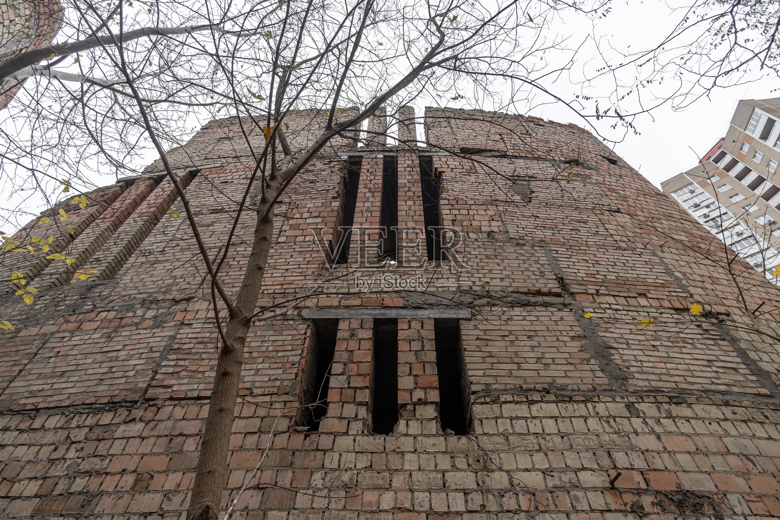 从下面仰视1980年代末文化宫的废弃未完成砖砌建筑。乌克兰基辅，维诺赫拉达尔。照片摄影图片