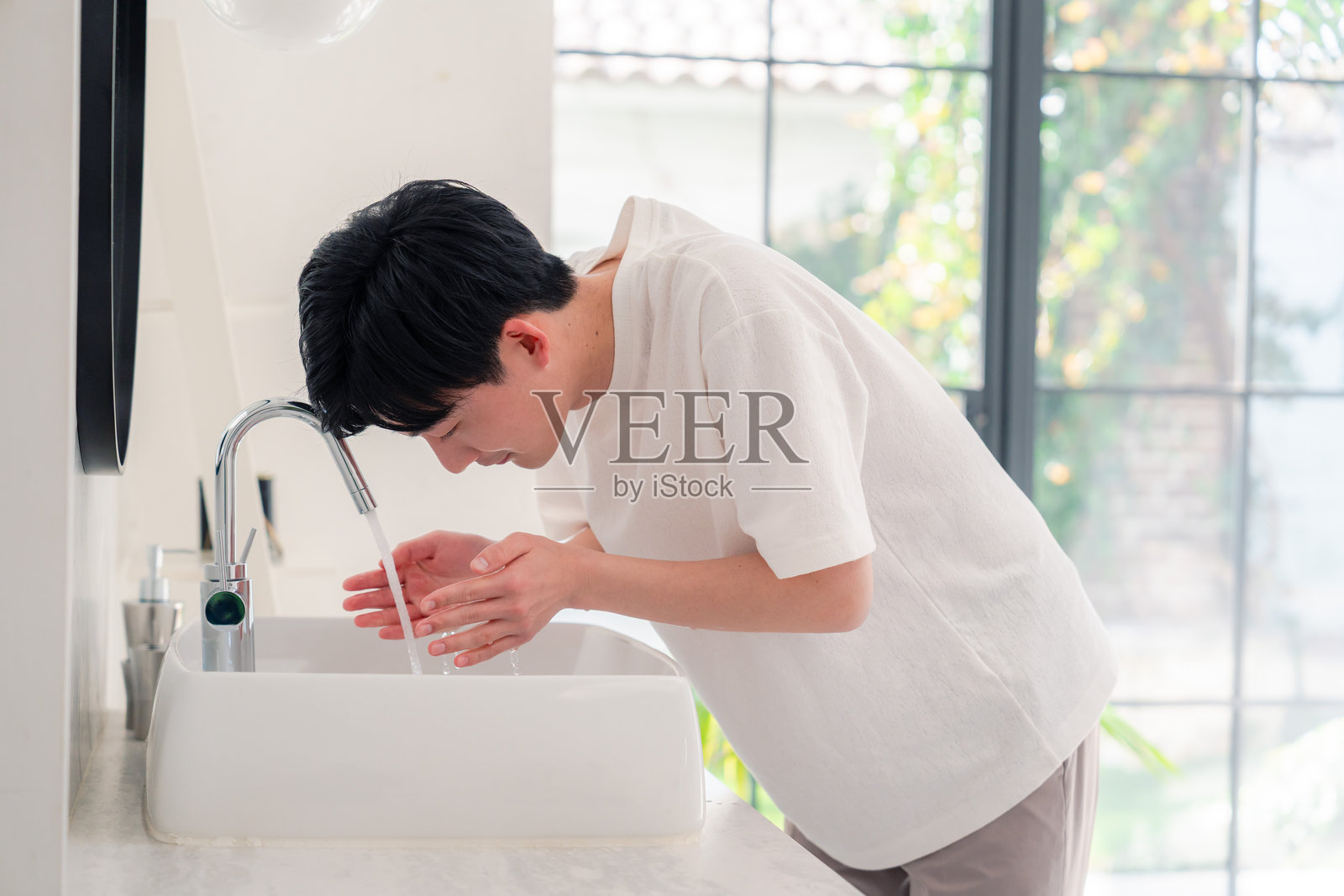 年轻男子在洗手间洗脸照片摄影图片