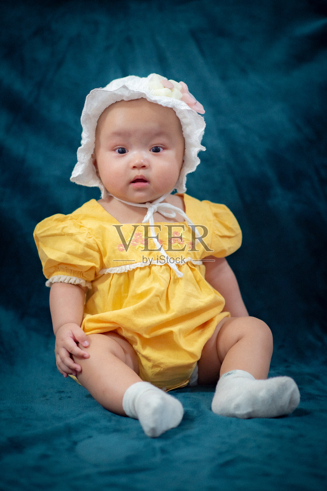 可爱男婴坐在家里的床上玩毛绒玩具的肖像照片摄影图片