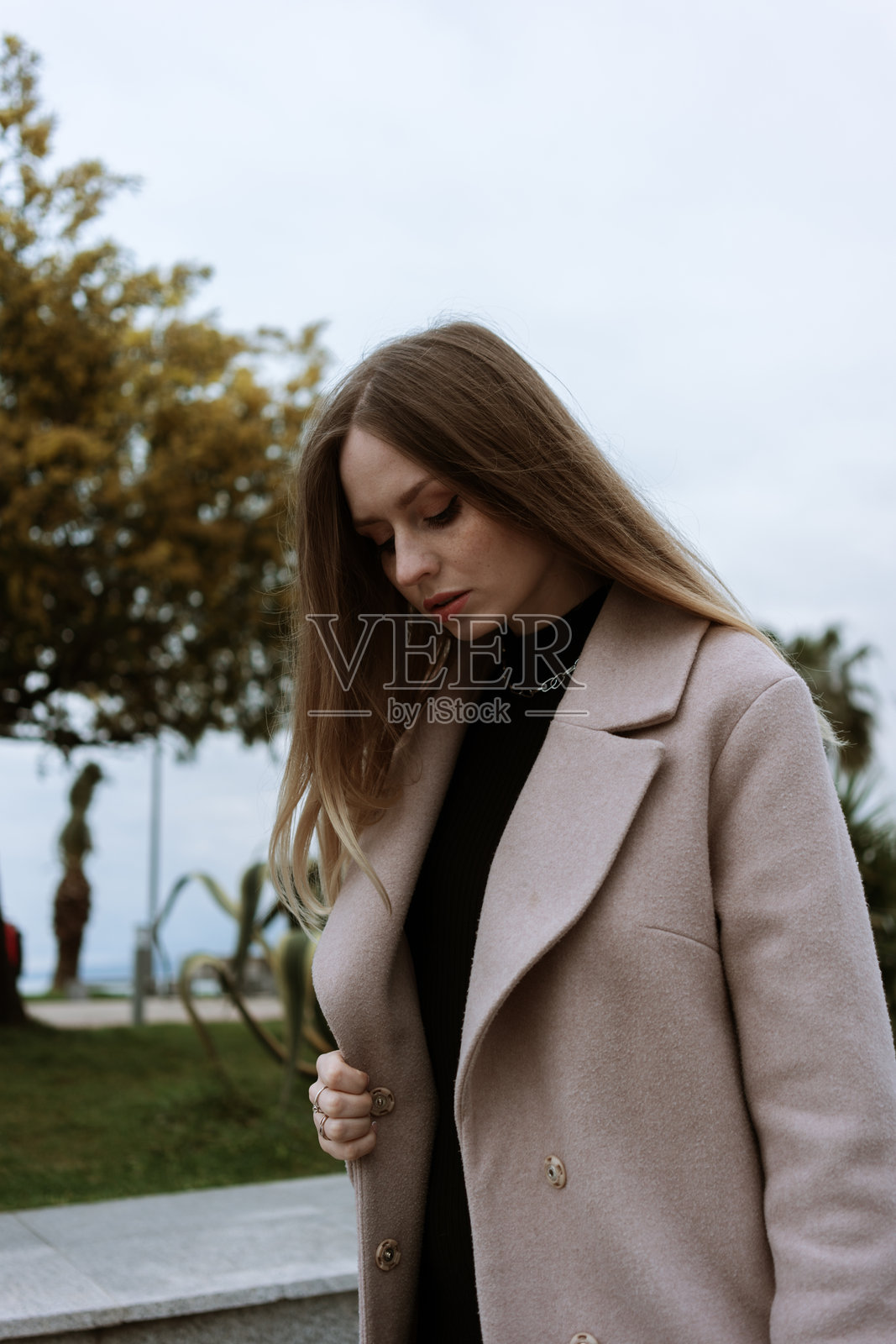 春天里，一位穿着外套的美丽快乐女孩在城市中漫步。肖像。高质量照片照片摄影图片