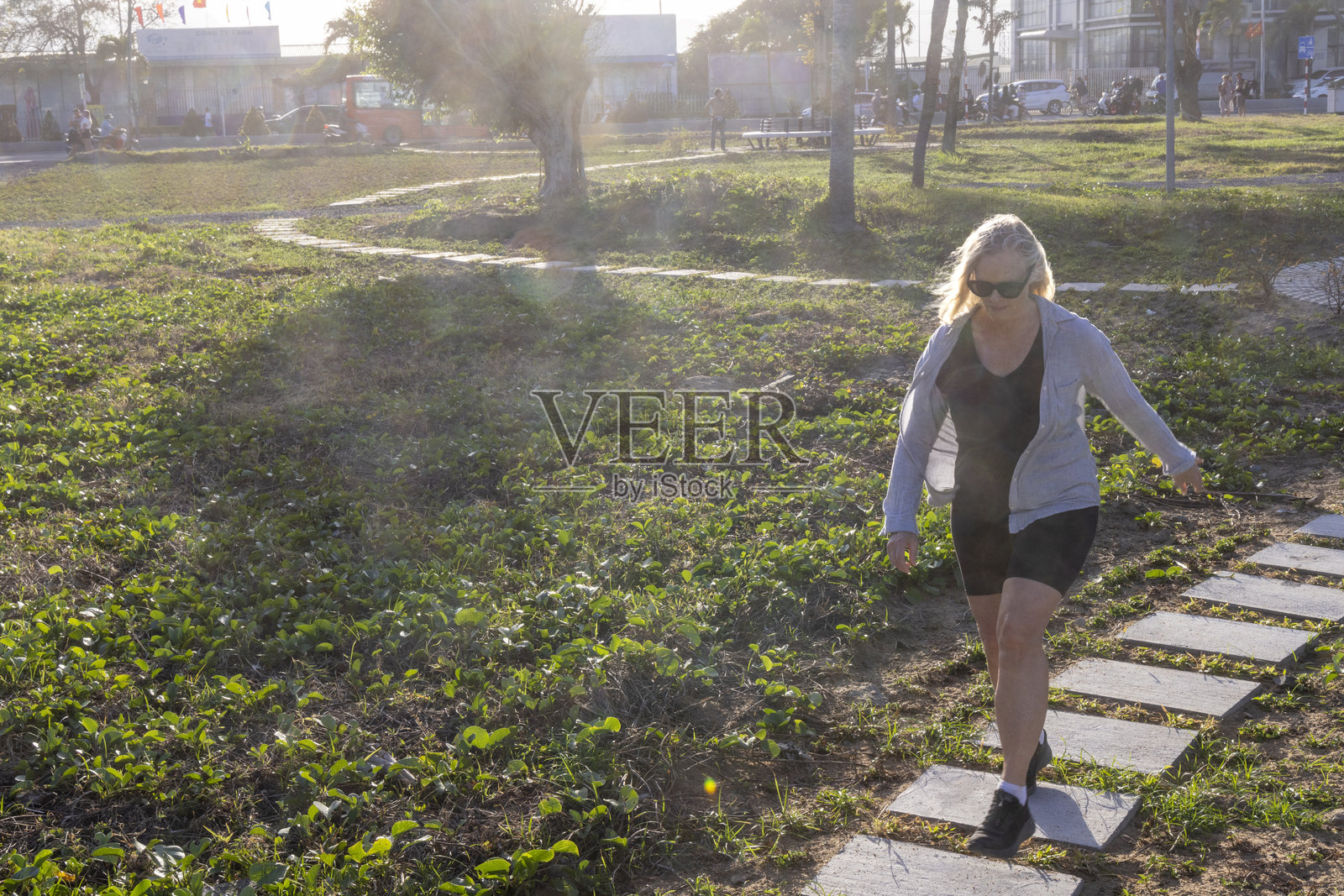 成熟的女性在铺路石之间跳跃照片摄影图片