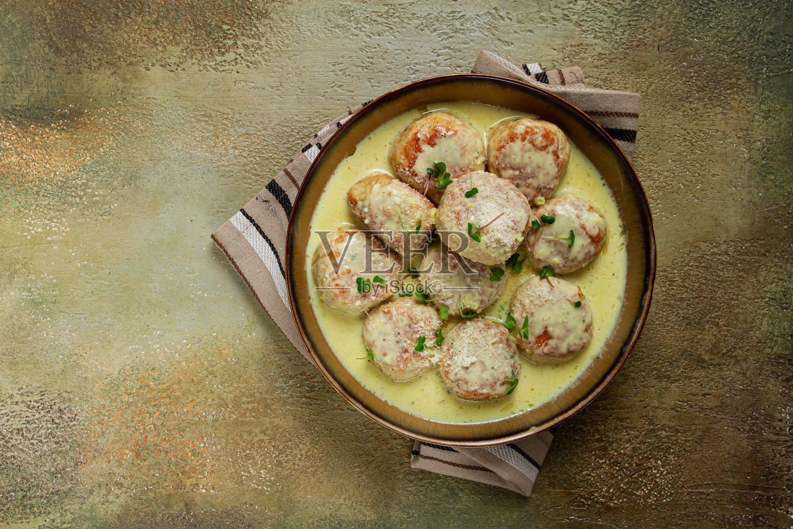 鸡肉丸，配奶油酱，撒上帕尔马干酪和微型绿叶，家常制作，无人出镜照片摄影图片