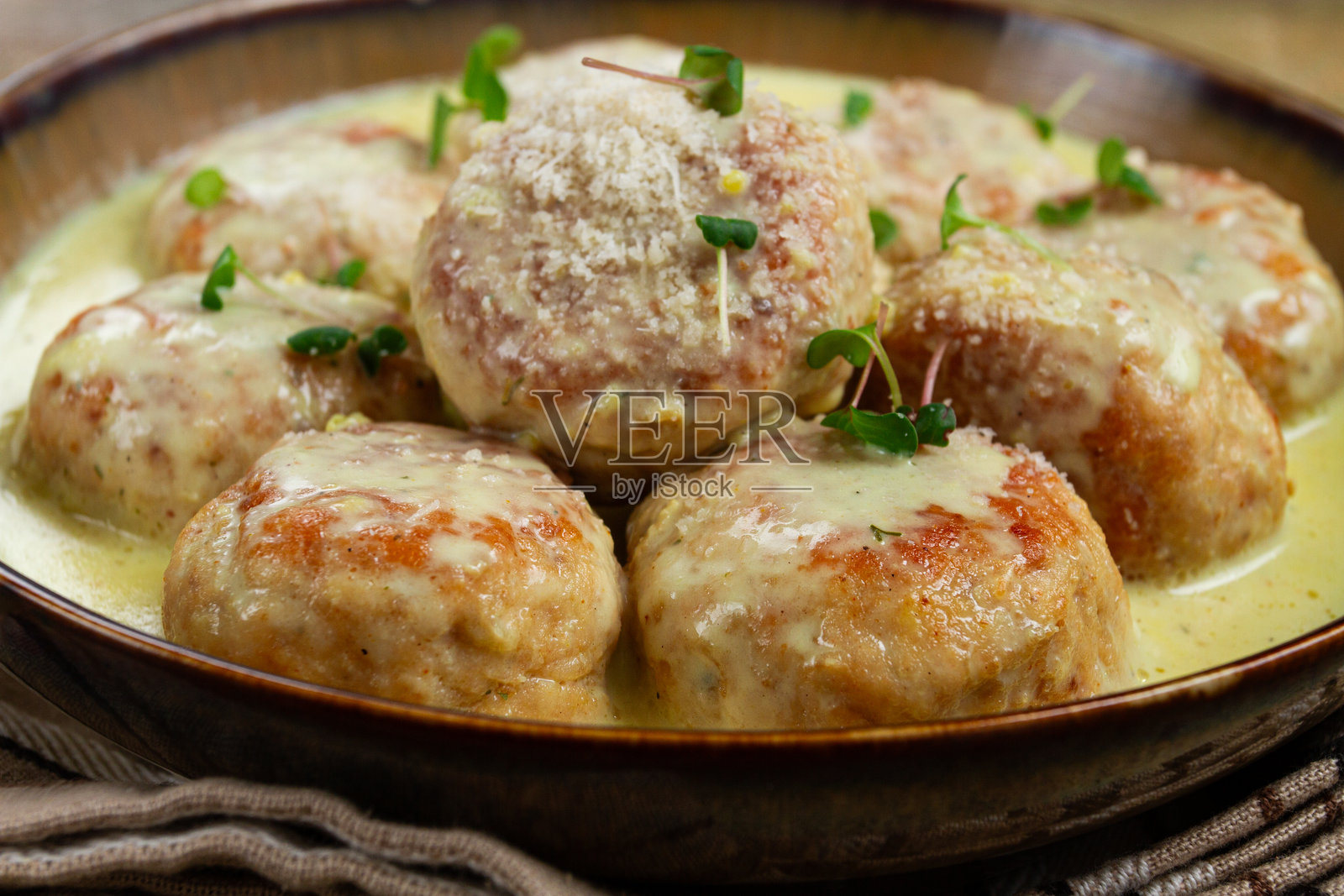 鸡肉丸，配奶油酱，撒上帕尔马干酪和微型绿叶，家常制作，无人。照片摄影图片