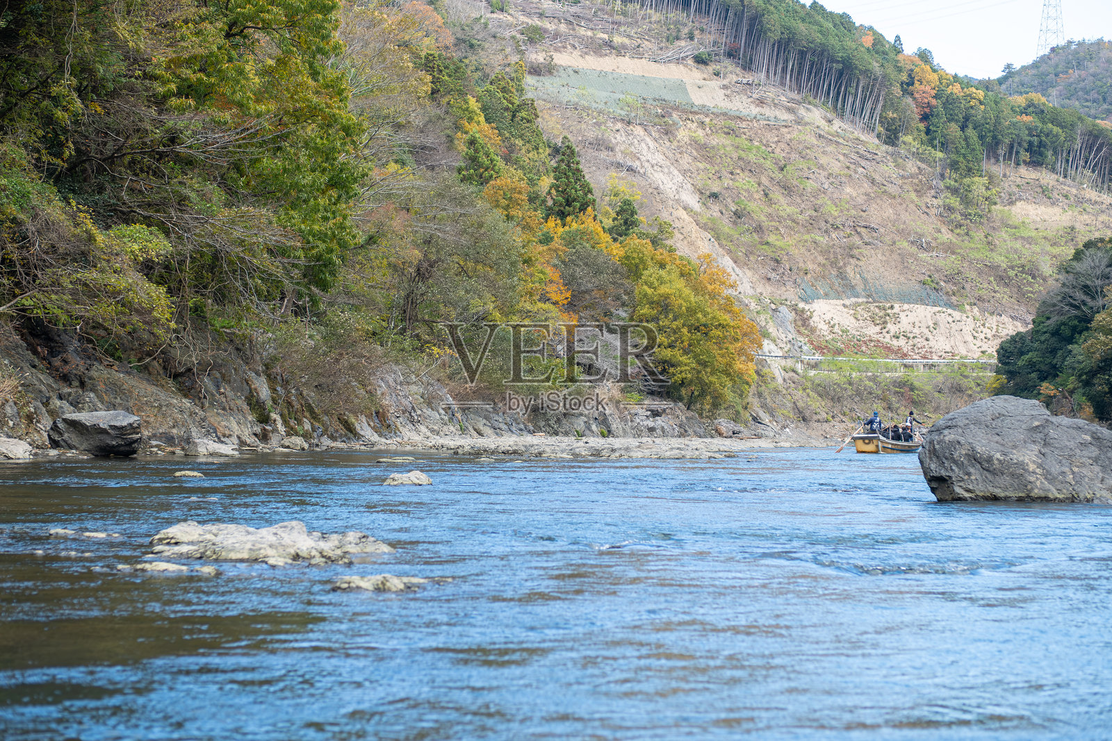 宁静的河流穿过色彩斑斓的秋季风景，位于保津川。照片摄影图片