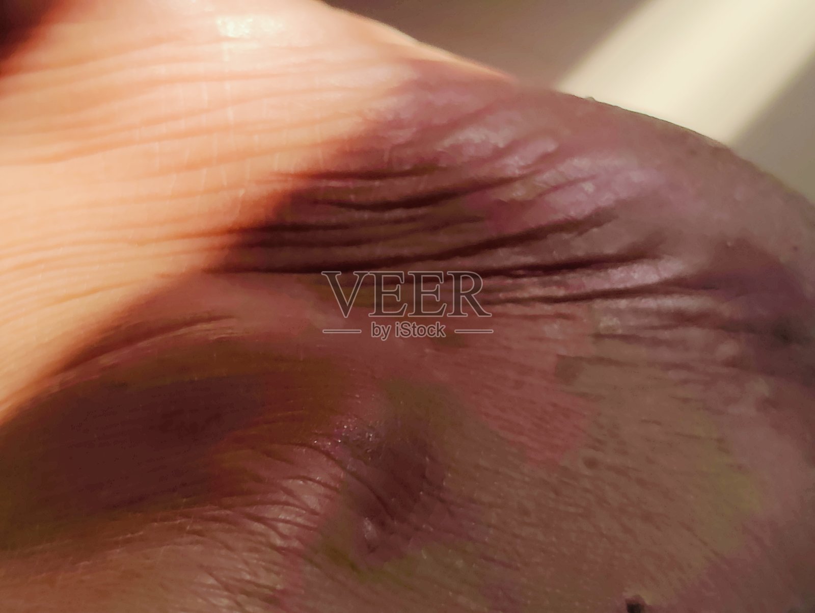 人脚皮肤纹理的特写，带有光效照片摄影图片