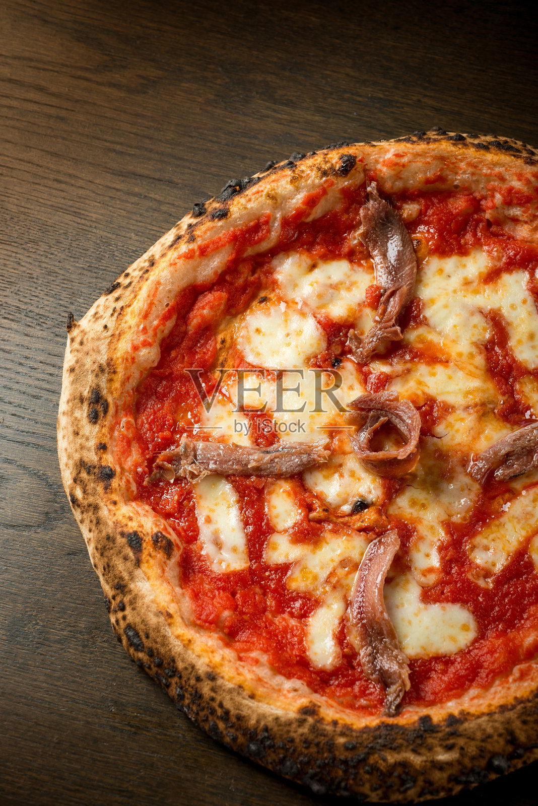 罗马披萨，配有番茄、马苏里拉奶酪和凤尾鱼照片摄影图片