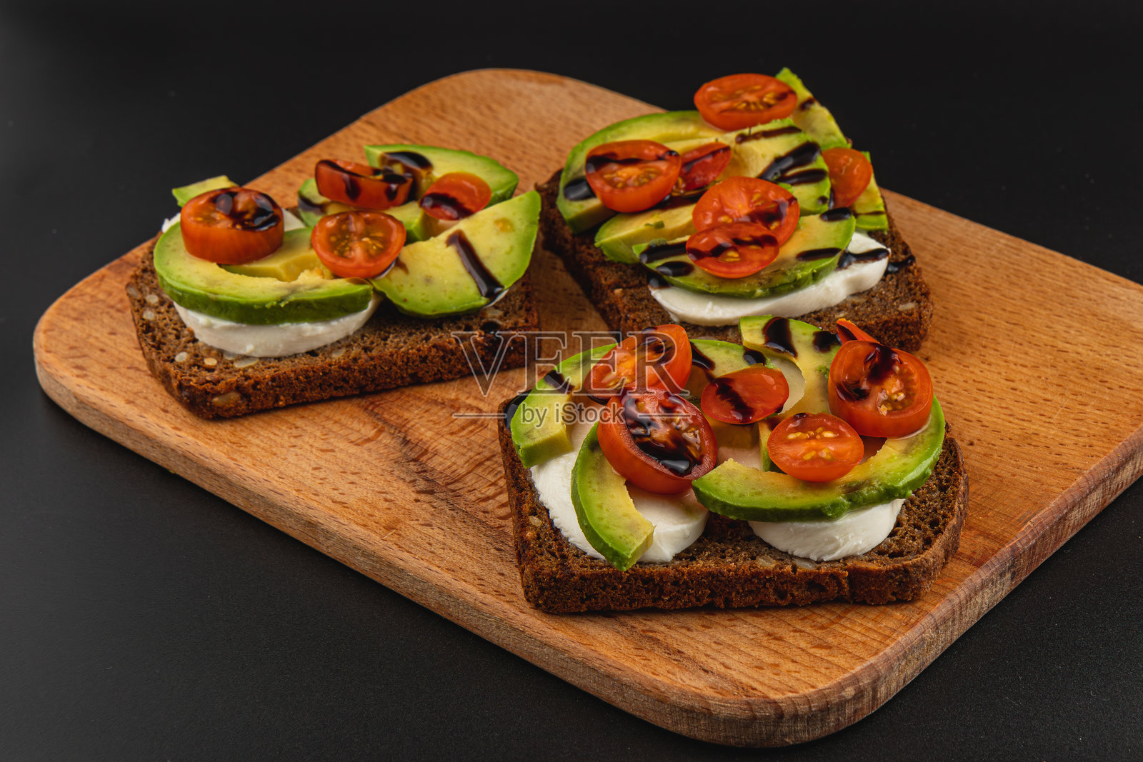健康的开放式三明治，配有鳄梨和烤番茄，搭配黑麦面包照片摄影图片