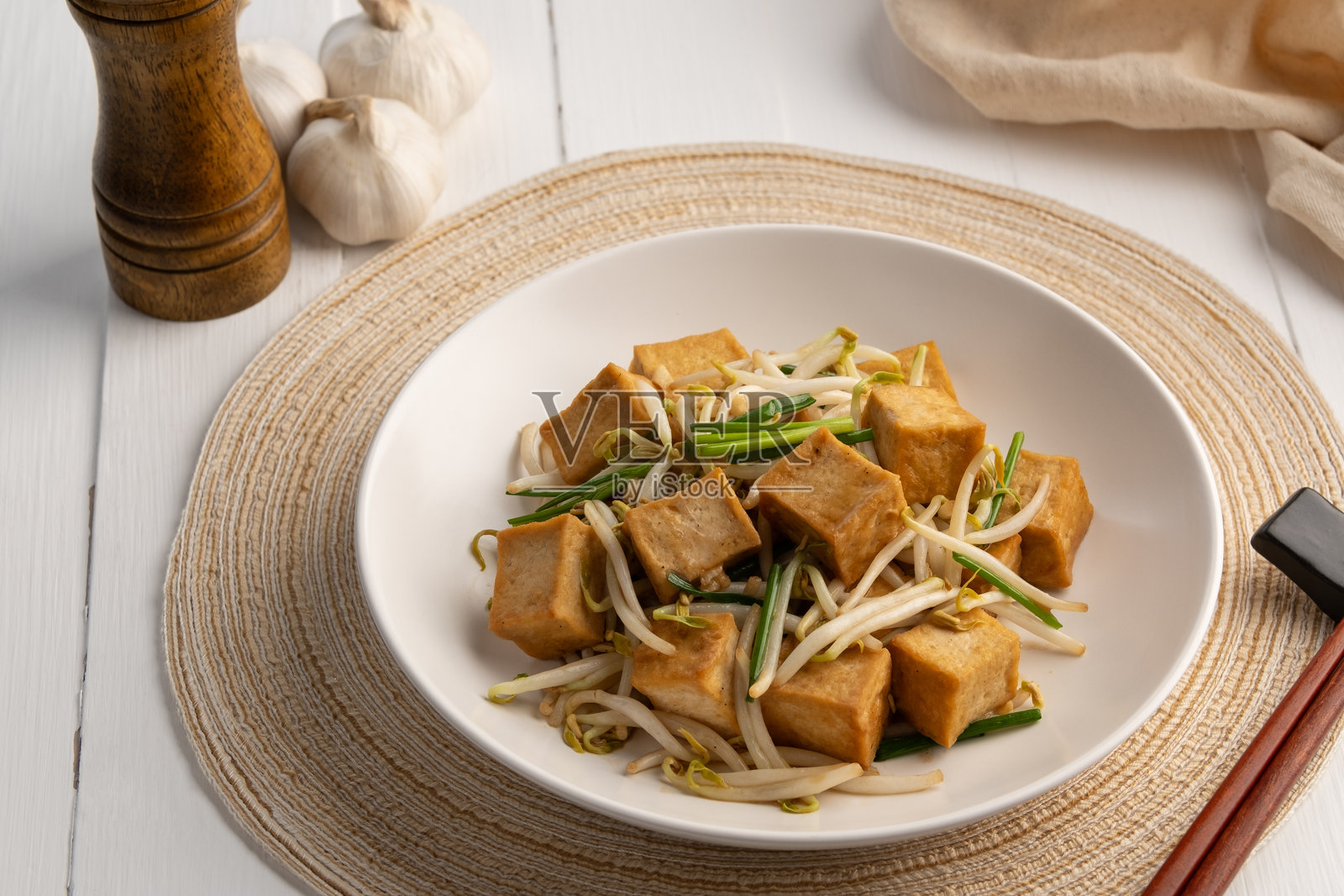 白盘中的炒硬豆腐与豆芽。照片摄影图片