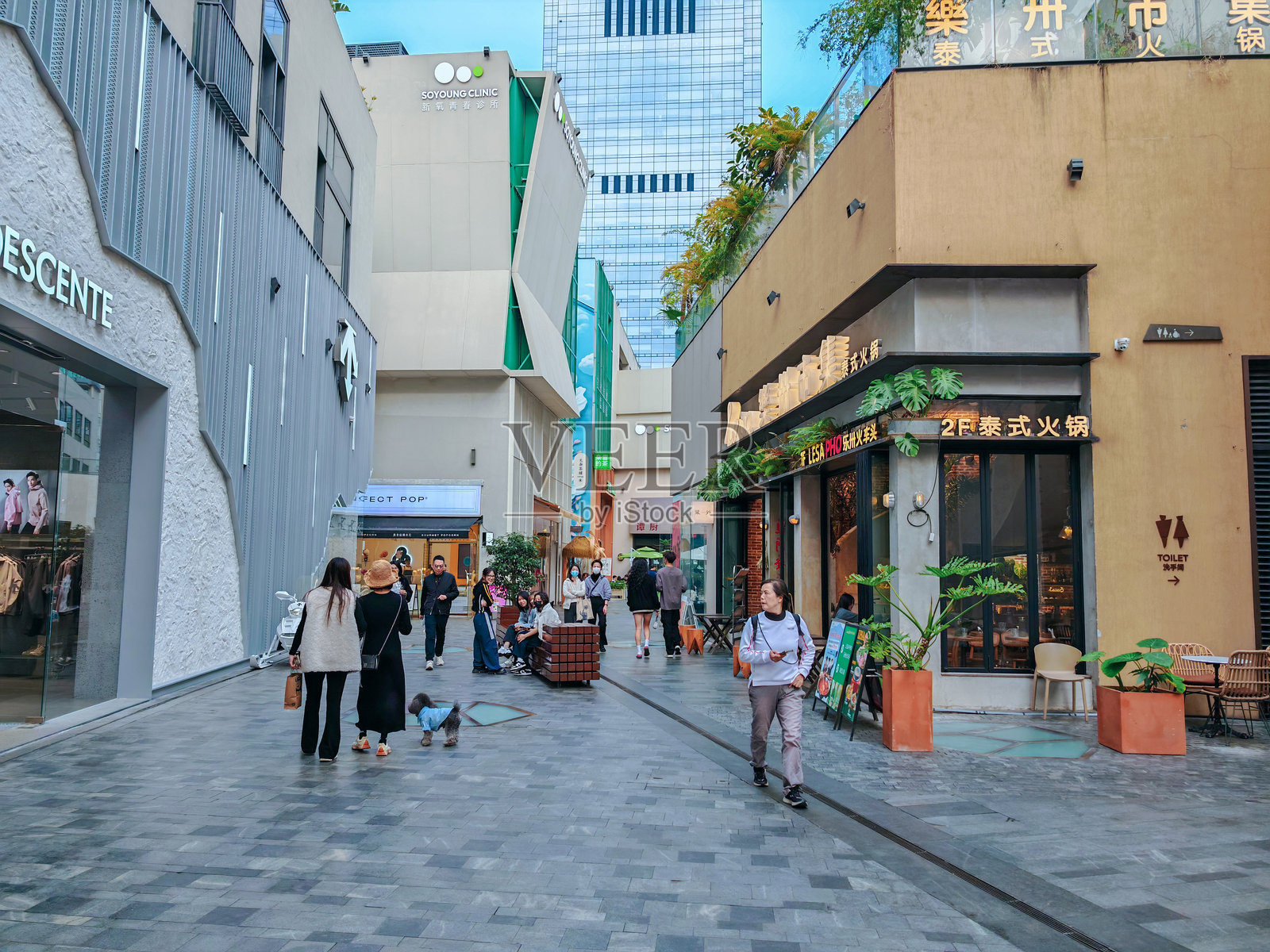 行人漫步在中国深圳的上坡购物中心，现代建筑和街景营造出充满活力的城市景象。照片摄影图片