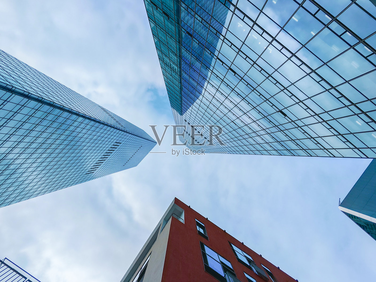 中国深圳上坡购物中心的现代建筑。摩天大楼在明亮多云的天空下，玻璃和钢铁向天空延伸。照片摄影图片