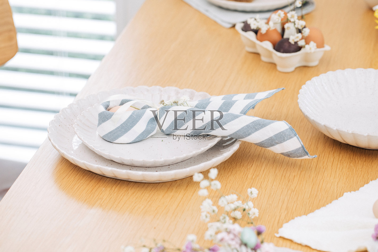 用亚麻餐巾包裹的兔子形状的复活节彩蛋，带着耳朵。复活节快乐照片摄影图片