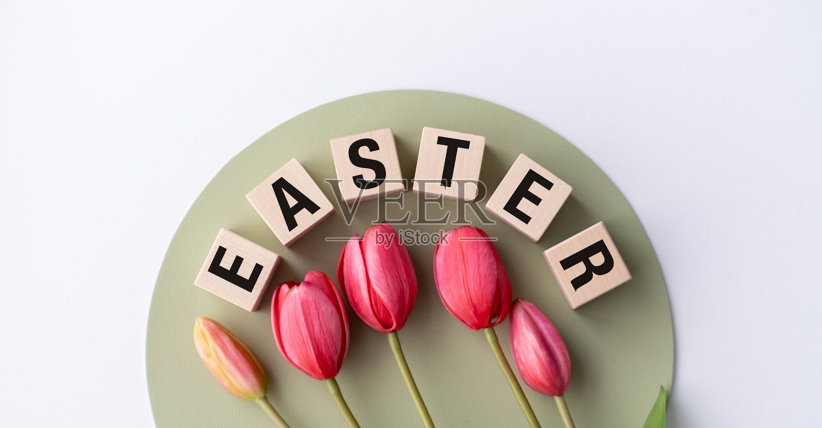 一圈红色郁金香排列成圆形，上面写着“复活节”照片摄影图片