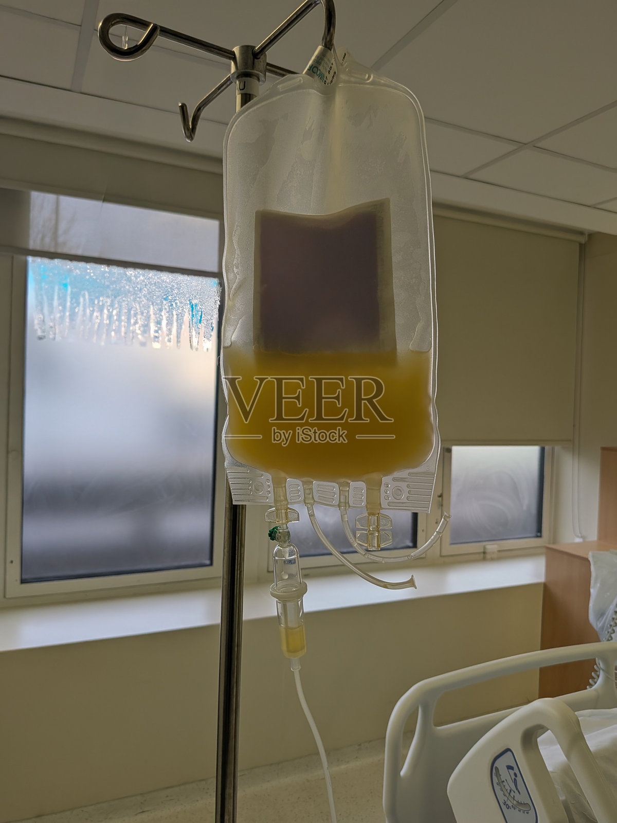 在治疗过程中，悬挂在支架上的静脉输液袋。照片摄影图片