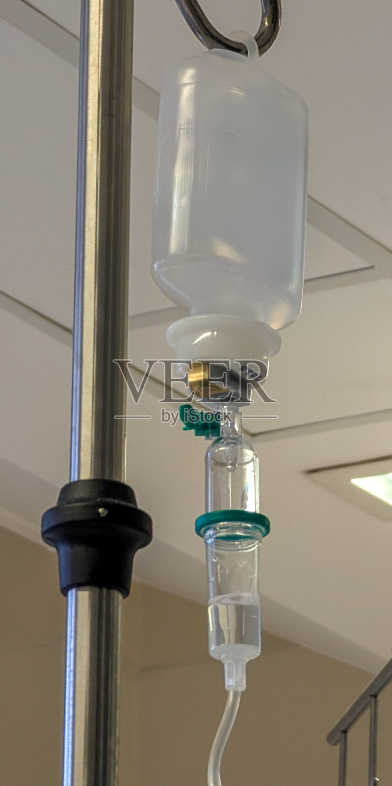 IV液体袋悬挂在医疗设施的支架上，为患者在治疗期间提供必要的水分补给照片摄影图片